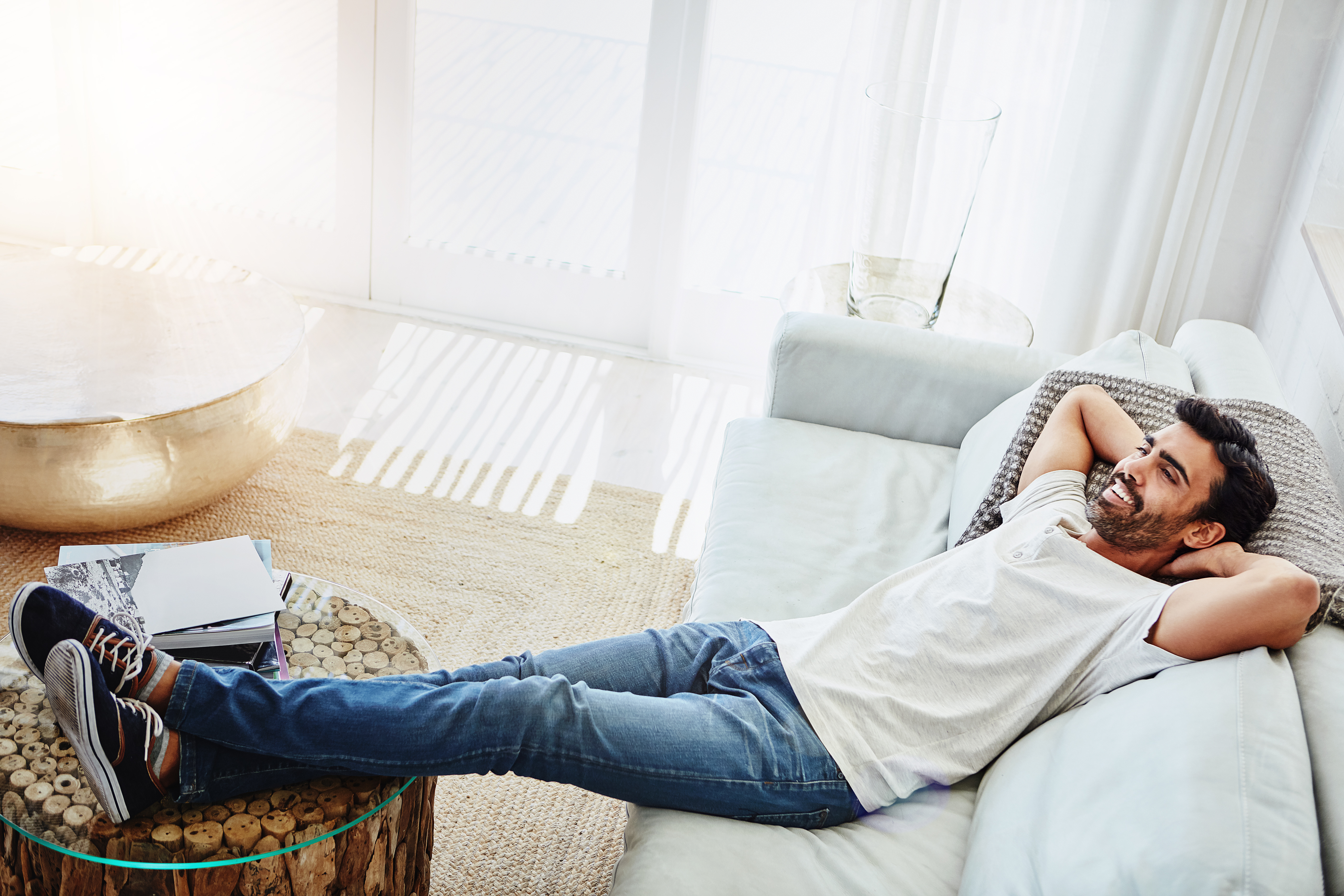 homme qui dort au soleil dans son canapé